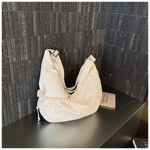 Detail view of the silver star pattern and drawstring design on the white dumpling bag