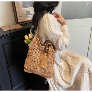 Detail of hollow woven cotton beach bag with wood beads and decorative tassels
