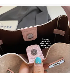 Detail view of strong magnetic closure on pink pebble leather bucket bag for women