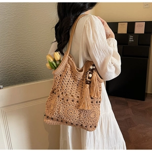 Detail of hand-woven crochet tote bag with hollow floral patterns and wood bead tassels