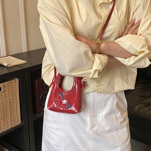 Detailed view of red quilted mini crossbody bag with colorful horse embroidery
