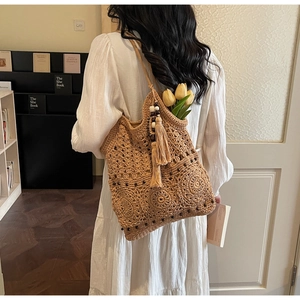 Detail of hand-woven shoulder bag with tassels, wooden beads and hollow out crochet texture
