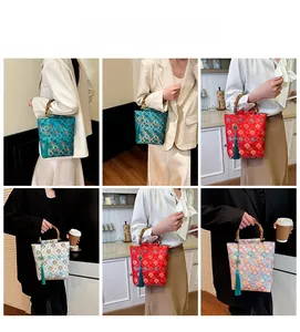 Detail view of Chinese style embroidered tote bags with bamboo handles and silk tassels