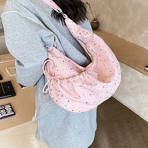 Close-up of pink crescent dumpling bag with silver star prints and pleated texture details