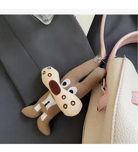 Cute brown plush dog charm with silver bead chain hanging on a creamy beige leather bag