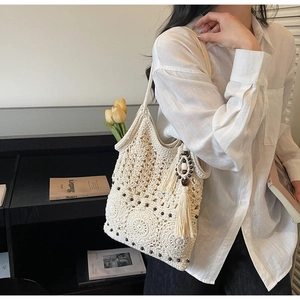 Detailed view of bohemian crochet shoulder bag with wooden beads and long tassels