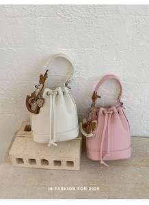 Detail of drawstring bucket bags with pebbled texture and a cute rocking horse charm