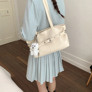 Minimalist cream white leather tote bag with buckle detail and plush puppy charm