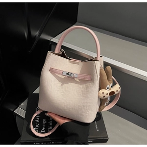 Detail of lychee pattern leather bucket bag with pink handle and silver twist lock