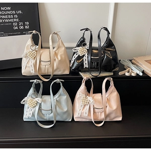 Dettaglio di quattro borse tote in ecopelle plissettata beige nero blu e rosa con ciondoli perla