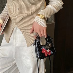 Close-up of quilted black mini crossbody bag featuring iconic horse embroidery detail