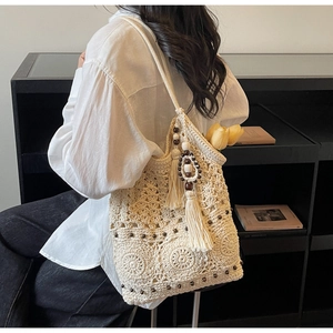 Detail of bohemian ivory crochet shoulder bag with wooden beads and long tassels