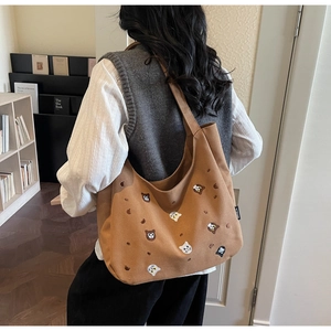 Close-up of brown canvas tote bag featuring cute cat embroidery for daily commuting
