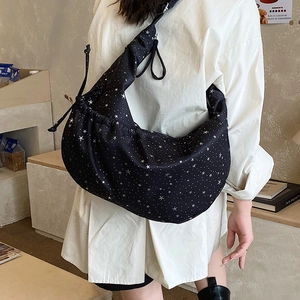 Detail of black cloud-shaped crossbody bag with star pattern and drawstring pleats