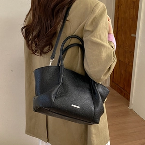 Détail du grand sac cabas vintage en cuir plissé noir avec bandoulière réglable