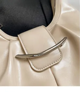Dettaglio della borsa beige in pelle verniciata a pieghe con fibbia in metallo argentato
