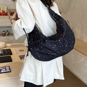 Detail view of the black moon bag with silver star prints and side drawstring accents