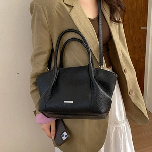 Sac fourre-tout noir à texture plissée avec bandoulière réglable porté en travers du corps