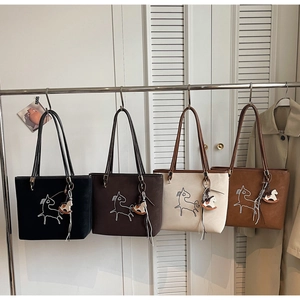 Group display of four textured tote bags with horse embroidery in a boutique setting