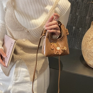 Detail of brown quilted mini crossbody bag with horse embroidery on elegant white knitwear