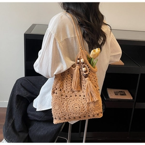 Detail of bohemian khaki woven shoulder bag with intricate crochet pattern and fringe