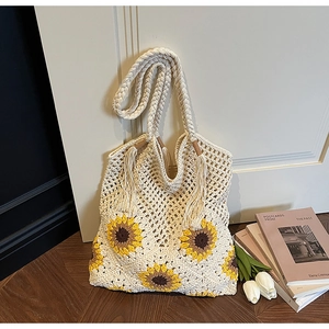 Detail of bohemian cream crochet tote bag featuring vibrant yellow sunflower embroidery