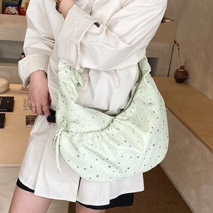 Detail of mint green hobo bag with black star prints and stylish drawstring side
