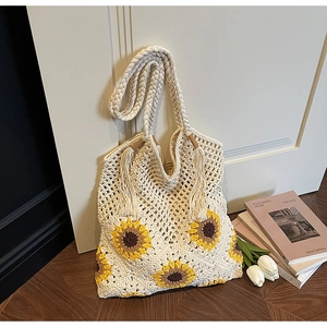 Detail of sunflower crochet pattern and twisted tassel straps on the beige woven tote