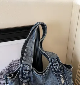 Macro detail of wide denim shoulder strap with washed vintage texture and rivets