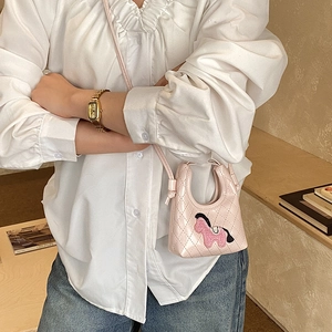 Detail of pink quilted mini crossbody bag with cute horse embroidery and thin strap