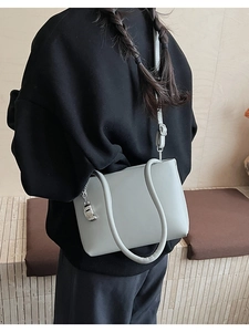 Detail of light blue crossbody bag featuring unique U-shaped design and adjustable strap