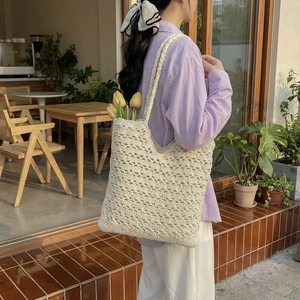 Pastoral style cream woven hollow tote bag shown as a spacious shoulder bag for women