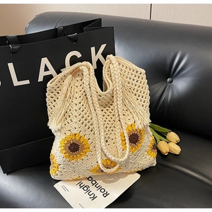 Detailed macro view of handcrafted woven straw tote bag with yellow sunflower patterns