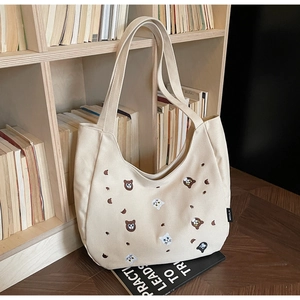Close-up of canvas tote bag featuring cute cartoon cat and bear embroidery details