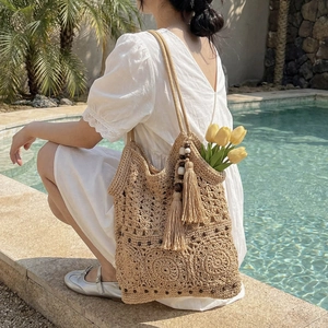 Beige crochet beach tote bag with wooden beads and fringes for vacation resort style