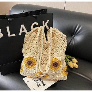 Detail of hand-woven sunflower tote bag with bohemian floral crochet and tassel charm