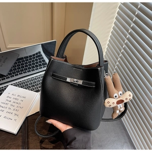 Detail of black lychee grain bucket bag with contrast stitching and silver twist lock