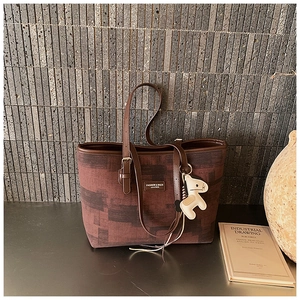 Detail view of the vintage tote bag featuring a leather horse charm and textured fabric