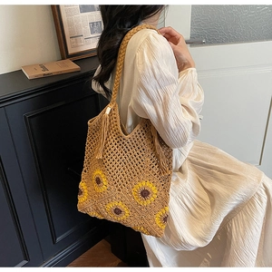 Detailed view of hand-woven shoulder bag featuring sunflower patterns and tassel details