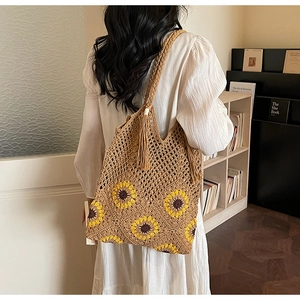 Close-up of crochet sunflower pattern on a brown woven tote bag with fringe