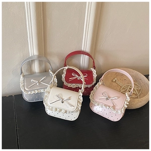 Detailed shot of mini lace bags in silver, red, beige, and pink with bow pendants