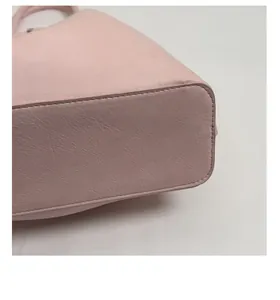 Détail du sac cabas rose clair montrant le fond renforcé et le cuir texturé grainé