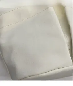 Dettaglio della trama del tessuto bianco crema leggero e delle cuciture della borsa