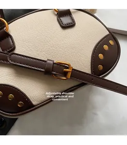 Detail of adjustable leather strap with gold metal rivets on a retro shoulder bag