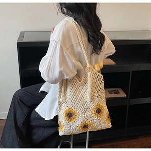 Detailed shot of hand-woven beige tote bag with sunflower motif and long tassel decoration