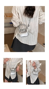 Detail showing silver mini bag with white lace trim and bow accent in a lifestyle setting