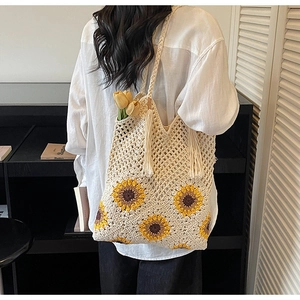 Detail of hand-crocheted tote bag with sunflower pattern and decorative tassel fringe