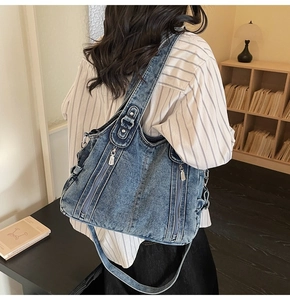 Detailed macro view of retro blue denim tote bag with silver zippers and multi-pocket design