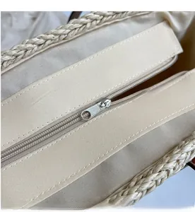 Detail shot of straw tote bag interior with smooth metal zipper and linen lining