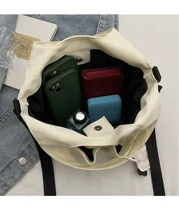 Vista dall'alto della spaziosa borsa tote crema con chiusura magnetica e oggetti vari